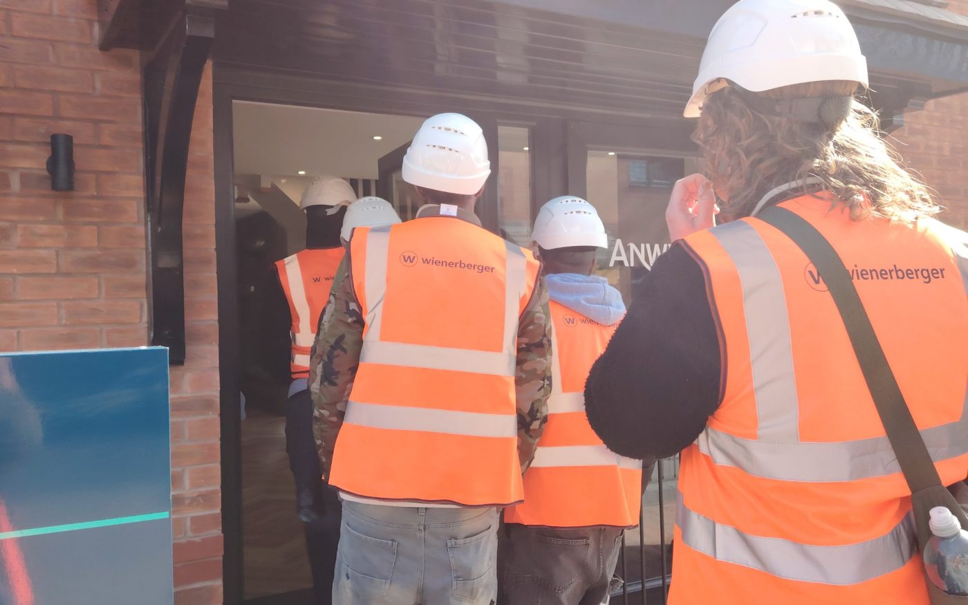 Young people watch Ian Martinson, carver of clay, work