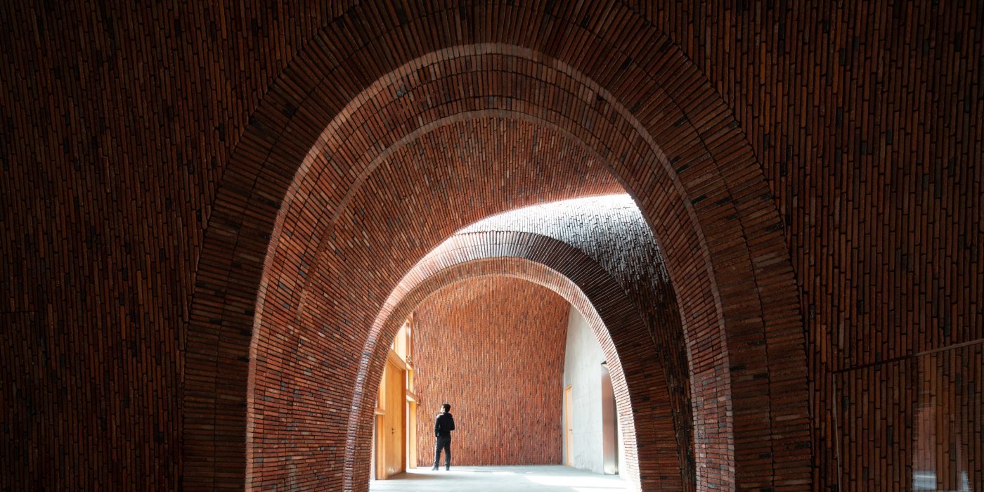 Man in brick archway of Imperial Kiln museum, Brick Award 22 winning design