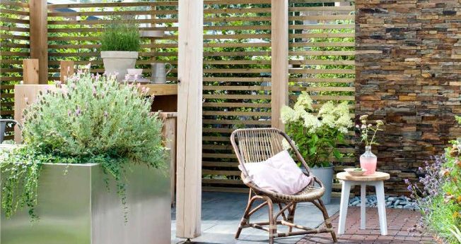 Stunning paved garden space with seating area and potted plants