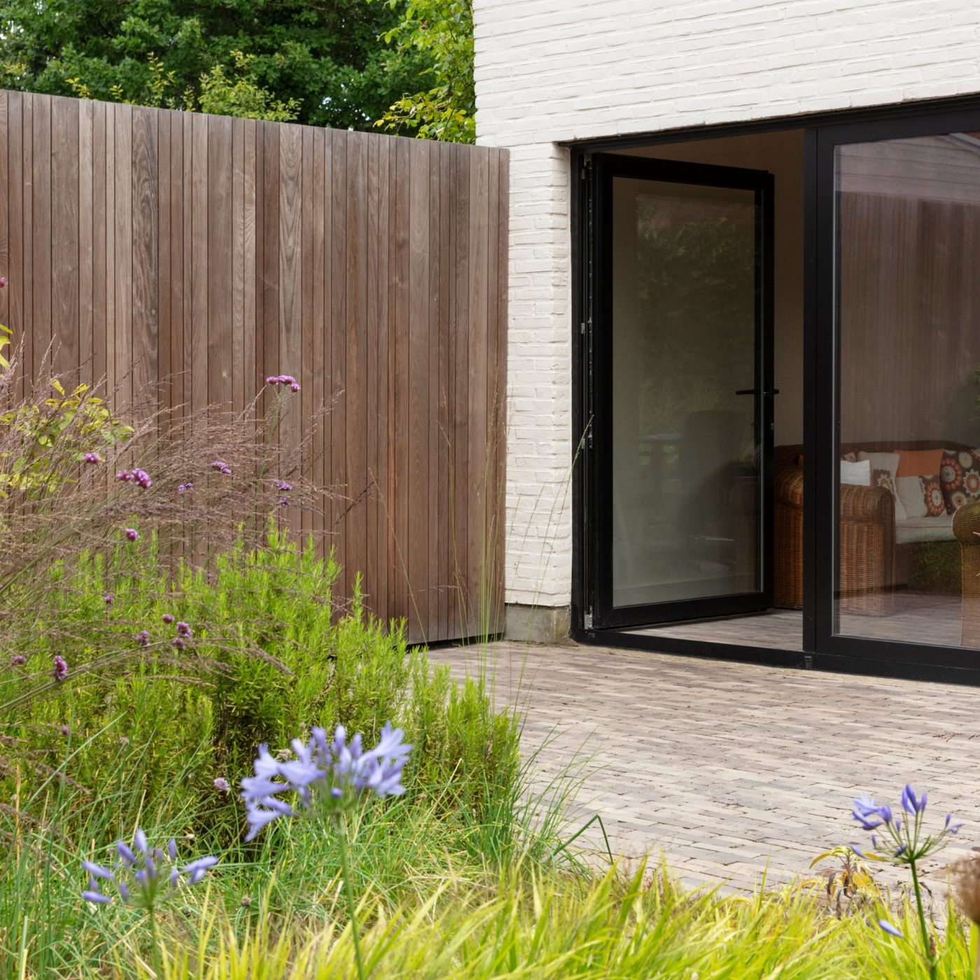 New garden with black bifold doors and wild plant garden