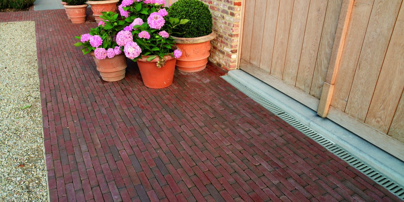 Red clay paving with flower pots in garden