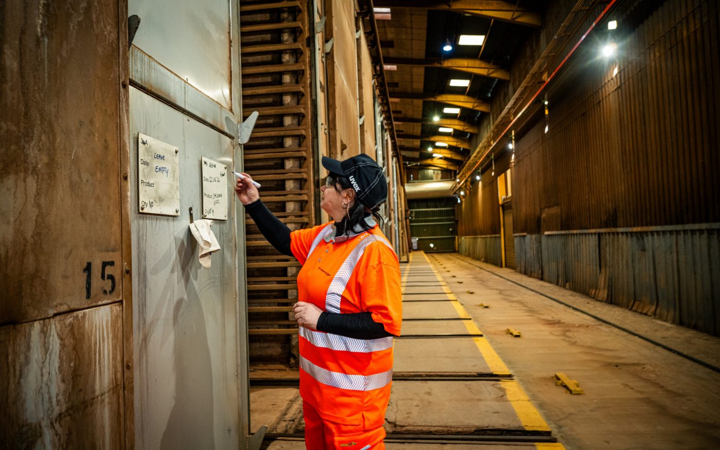 Image of a woman in construction writing on a wall
