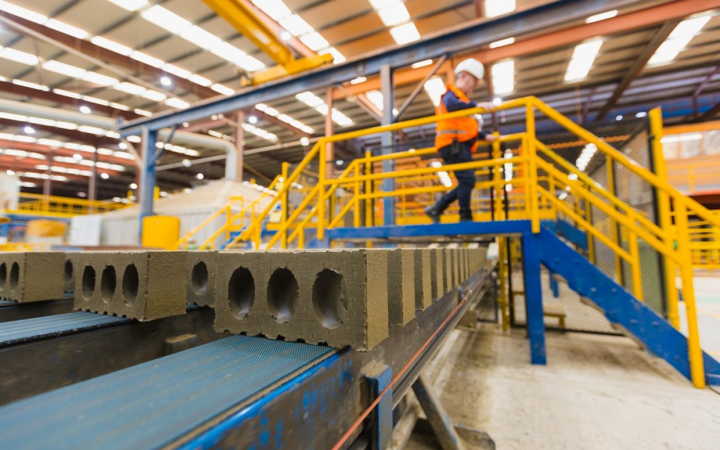 Man in factory examining brick quality