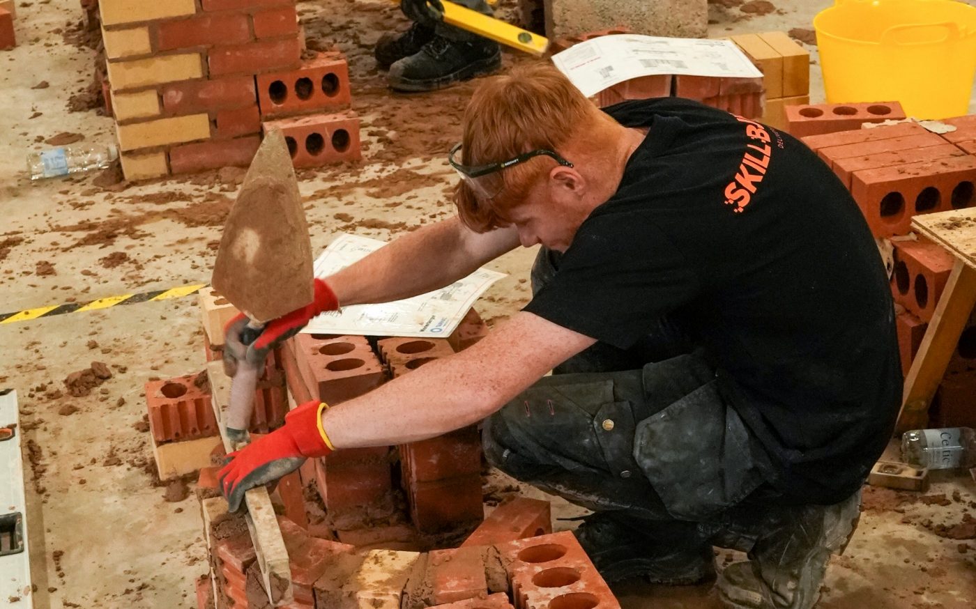 Man building impressive brick wall in competition