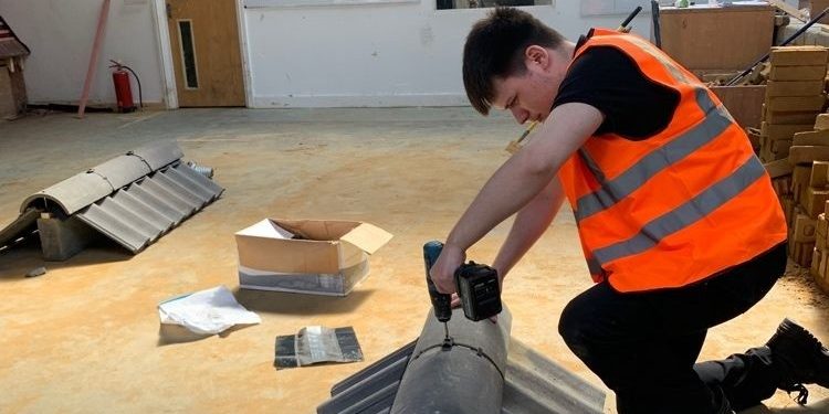 Decorated bricks displayed in a line on a long green display stand