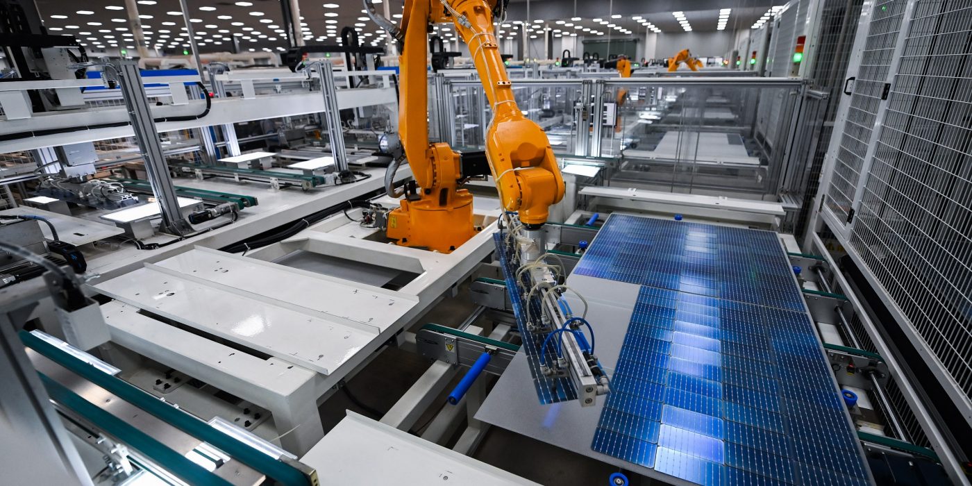 Robot arm on production line at solar panel plant