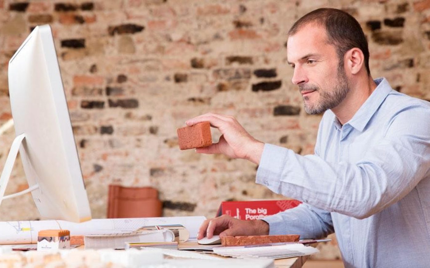 Architect comparing brick sample to computer