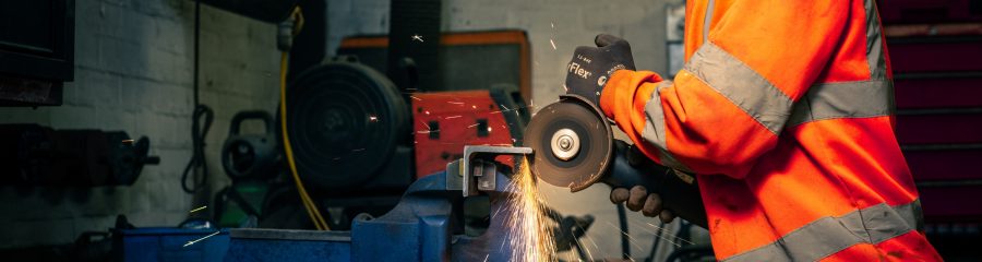 Apprentice using machinery in the factory that produces sparks