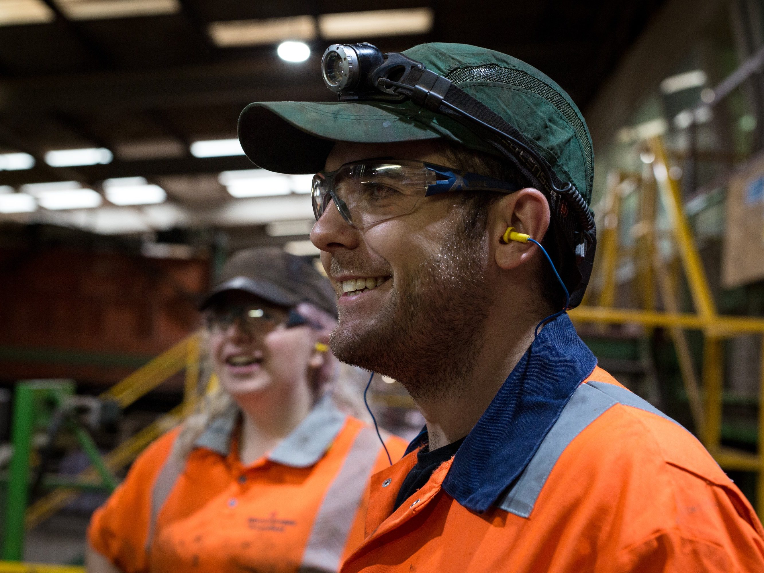 Man and women in a factory smiling