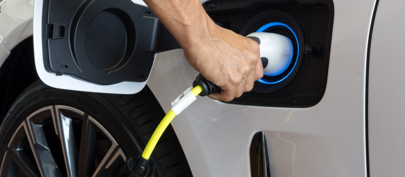 Man charging an electric vehicle