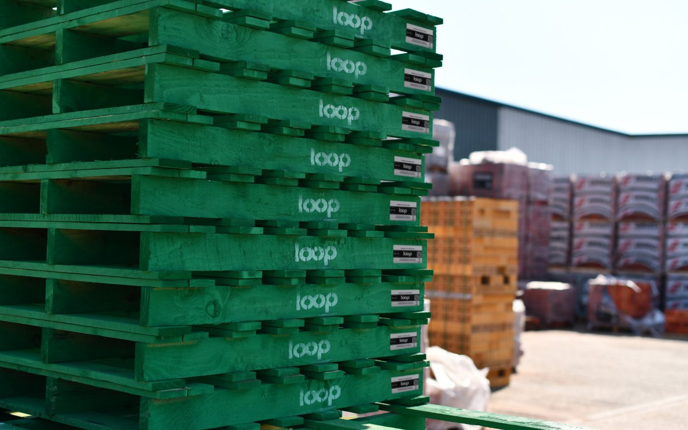 stacked green pallets with the word 'loop' in white