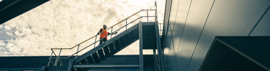 Man walking up external steps outside factory