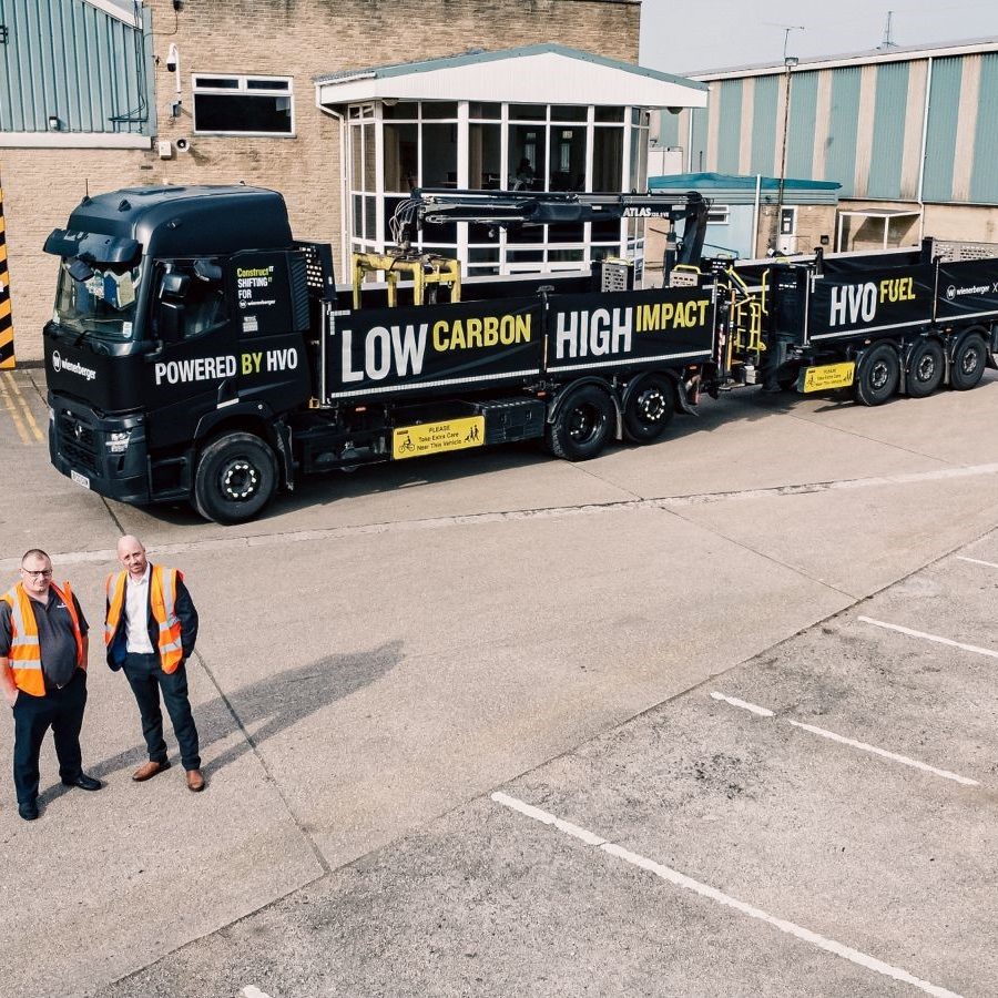 Two employees stook next to first HVO powered brick delivery vehicle
