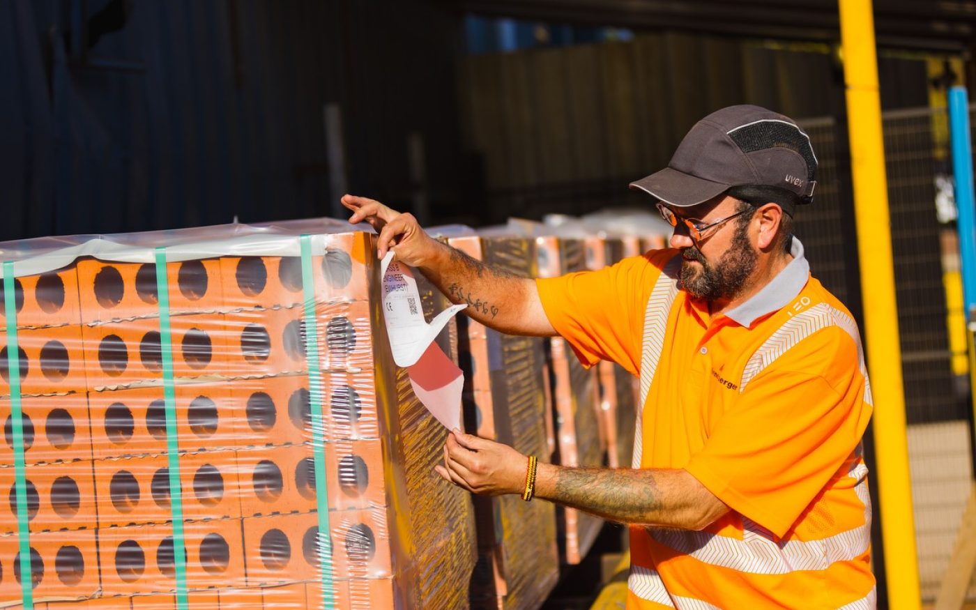 Wienerberger employee putting sticker on pallet of bricks