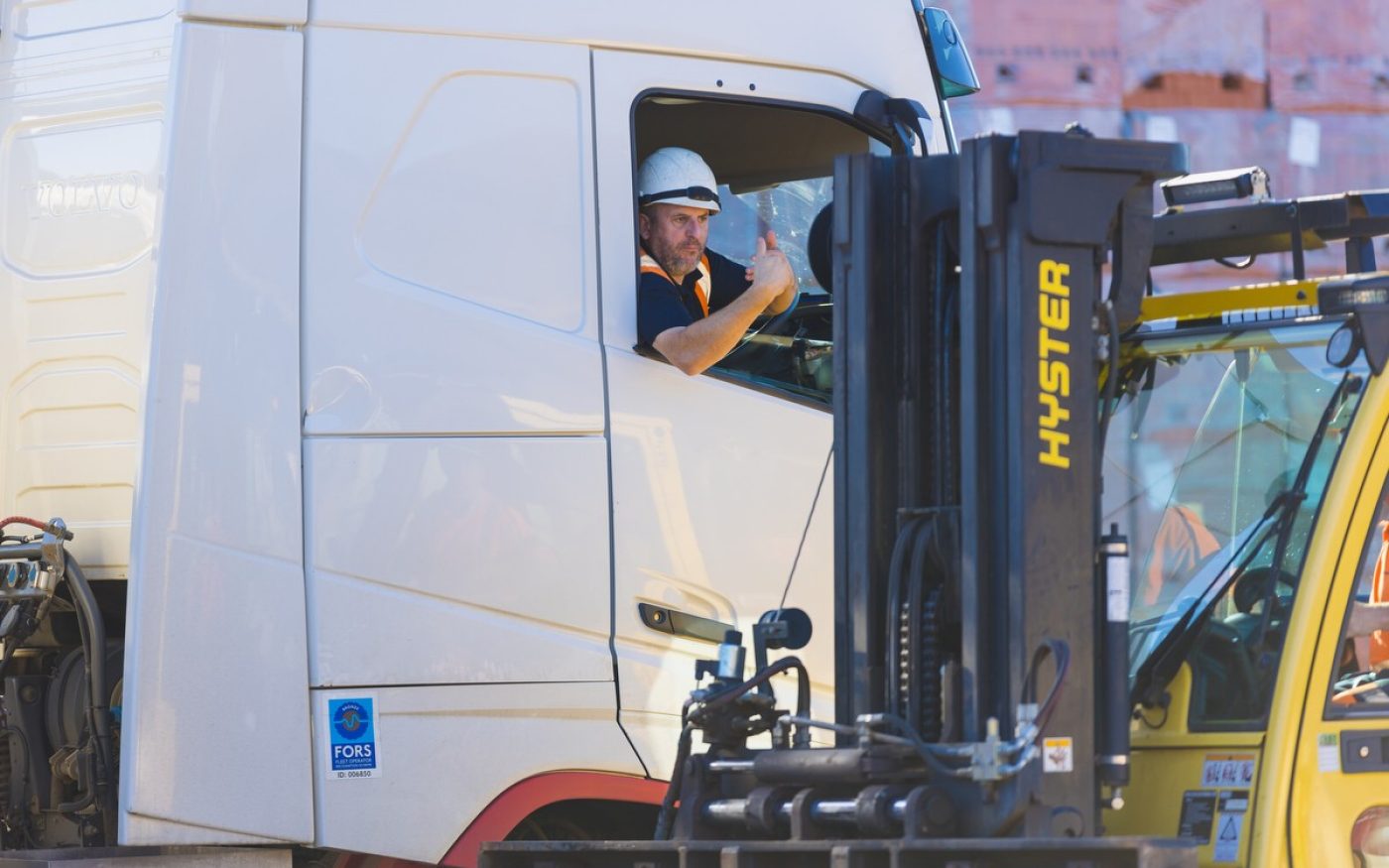 Man in lorry giving thumbs up, ready to deliver bricks