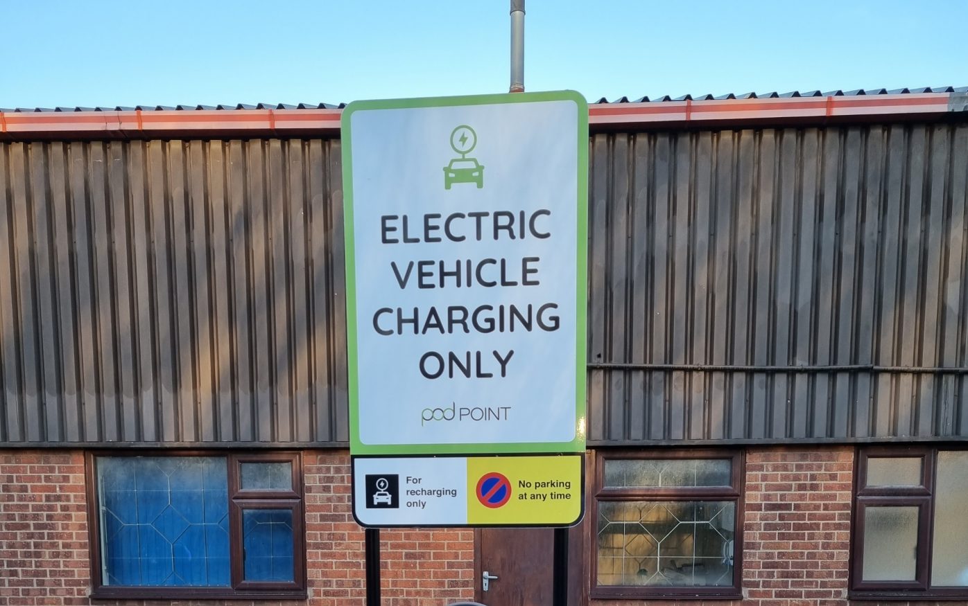 Man watching brick pallets being loaded onto flatbed lorry