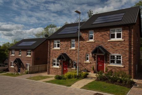 Finished residential building project with red brickwork and solar panels on roof