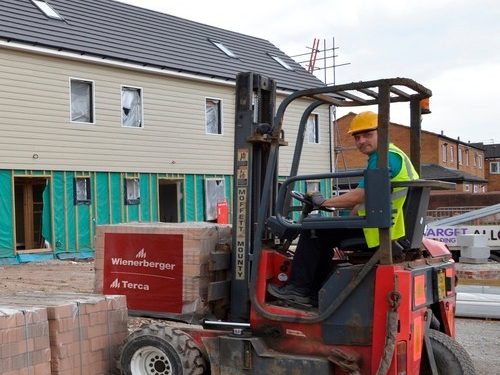 Man on a fork lift moving a batch of wienerberger bricks