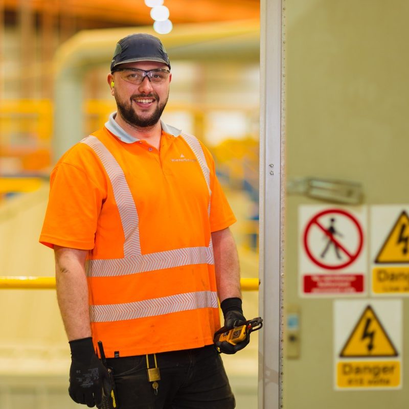 Man in safety gear with health and safety signage