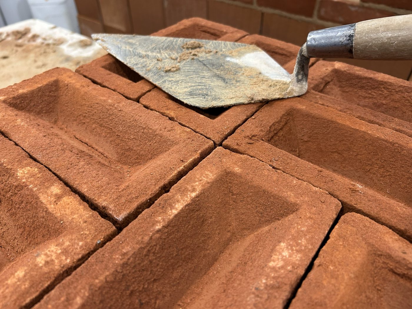 Close up of red bricks and a trowel