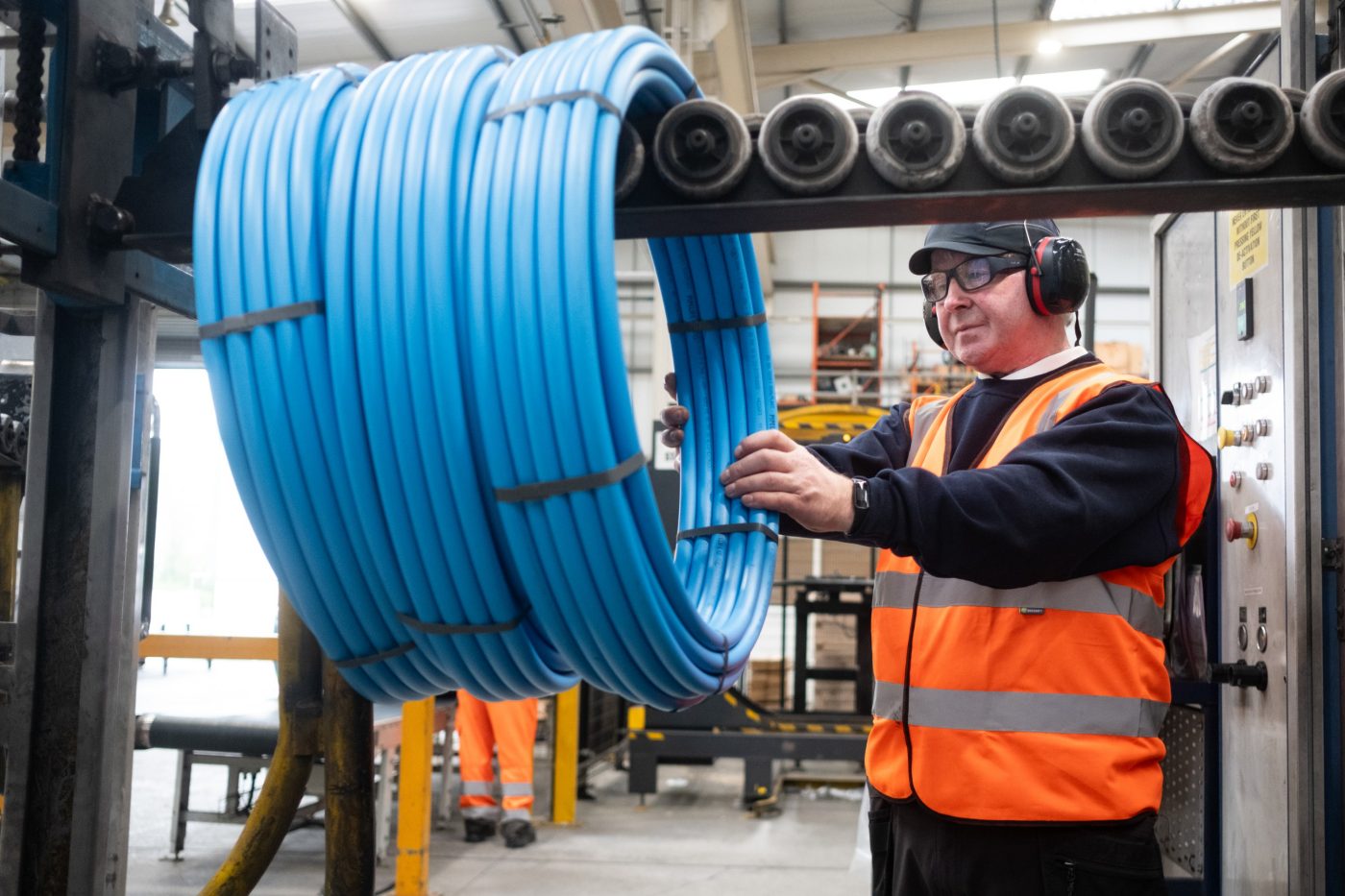 Man working with long blue pipes from Pipelife