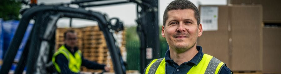 Man in high-viz vest in front of forklift