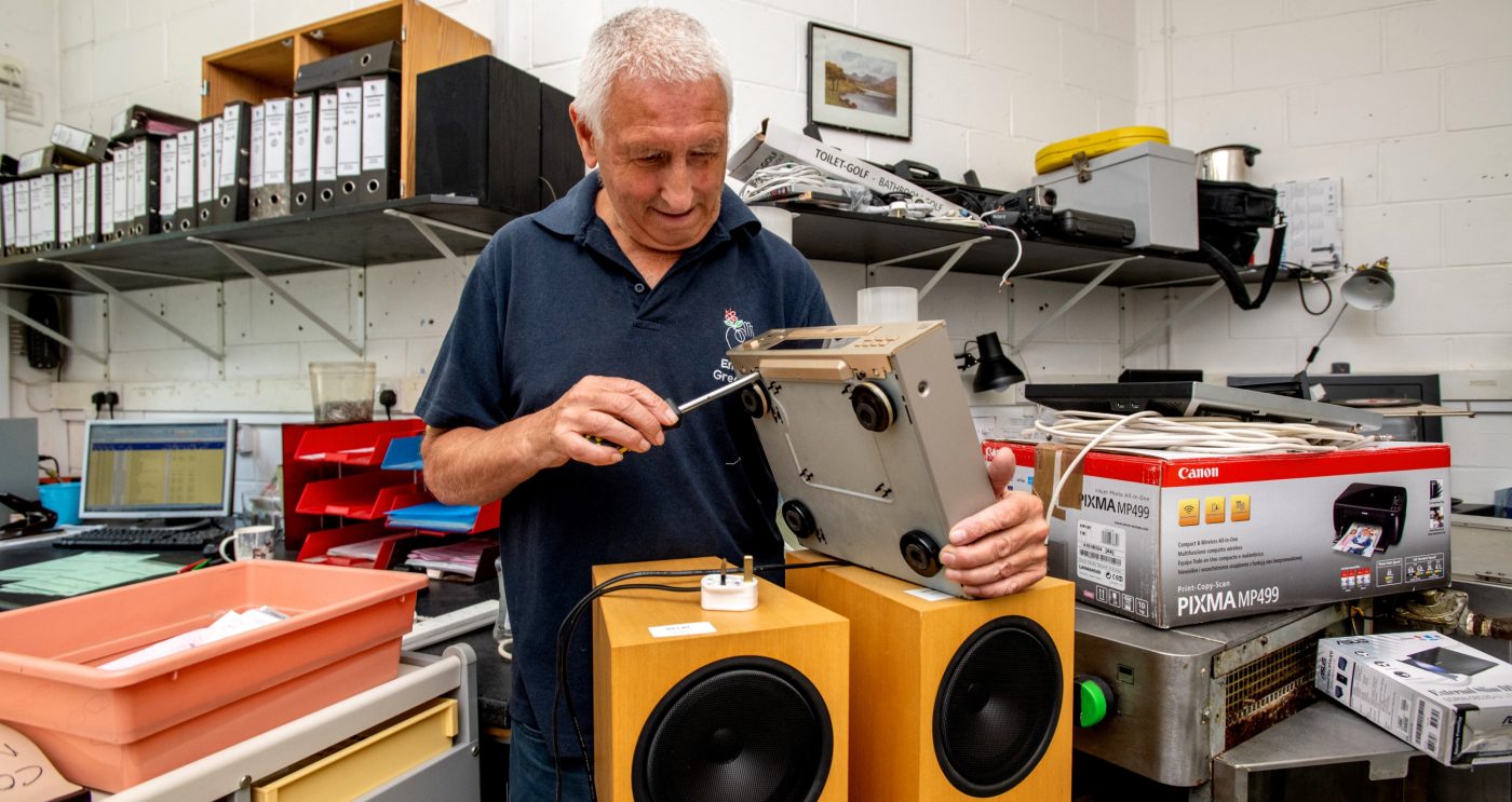 Man from Emmaus UK using a screwdriver to fix equipment