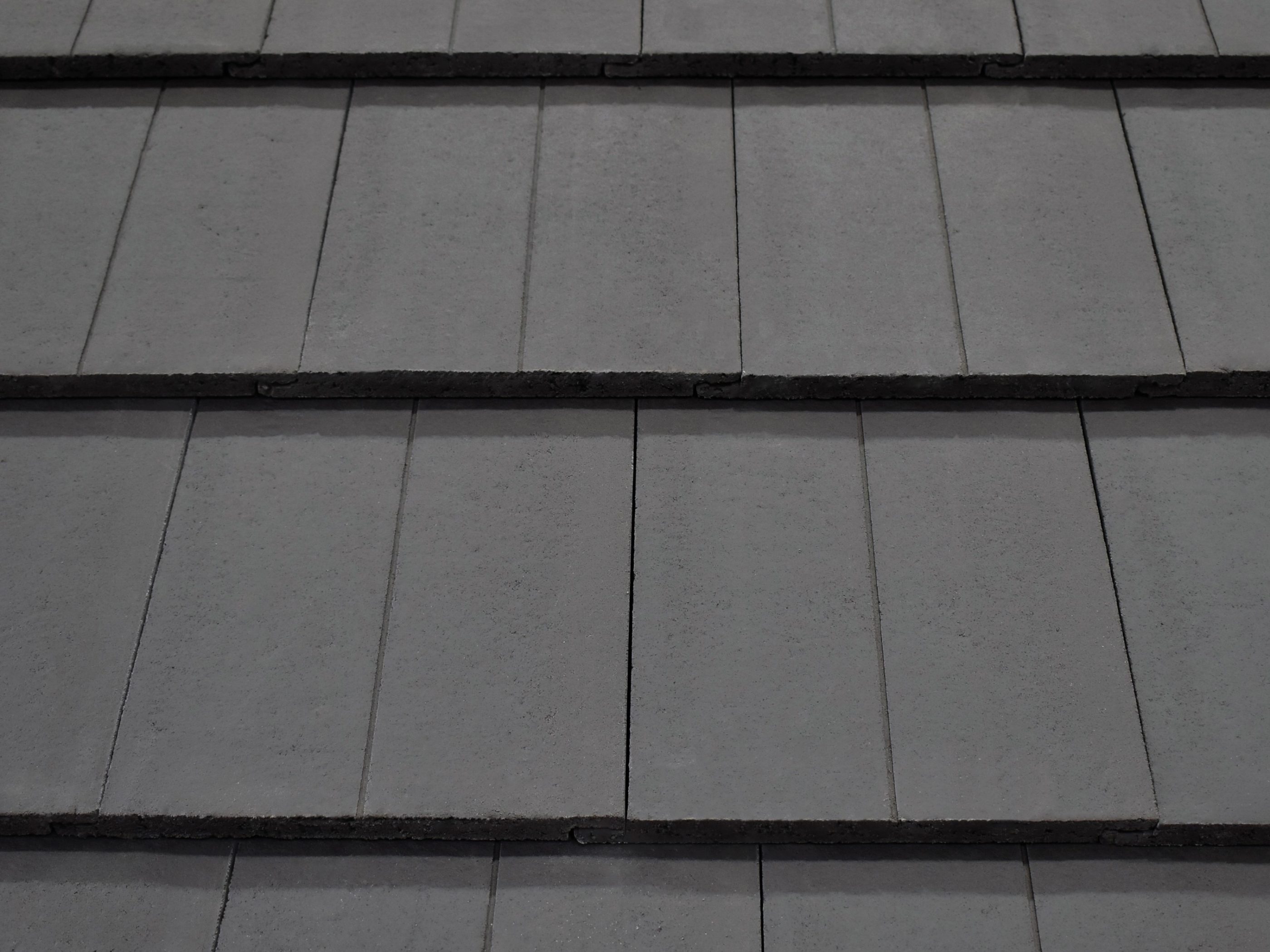 Grey roof tiles arranged on a sloped roof