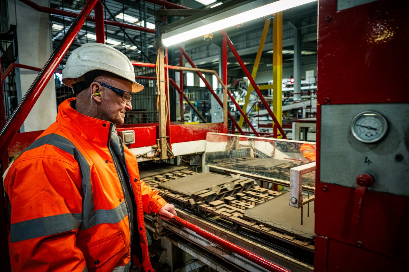 factory employee looking at a section of tile production