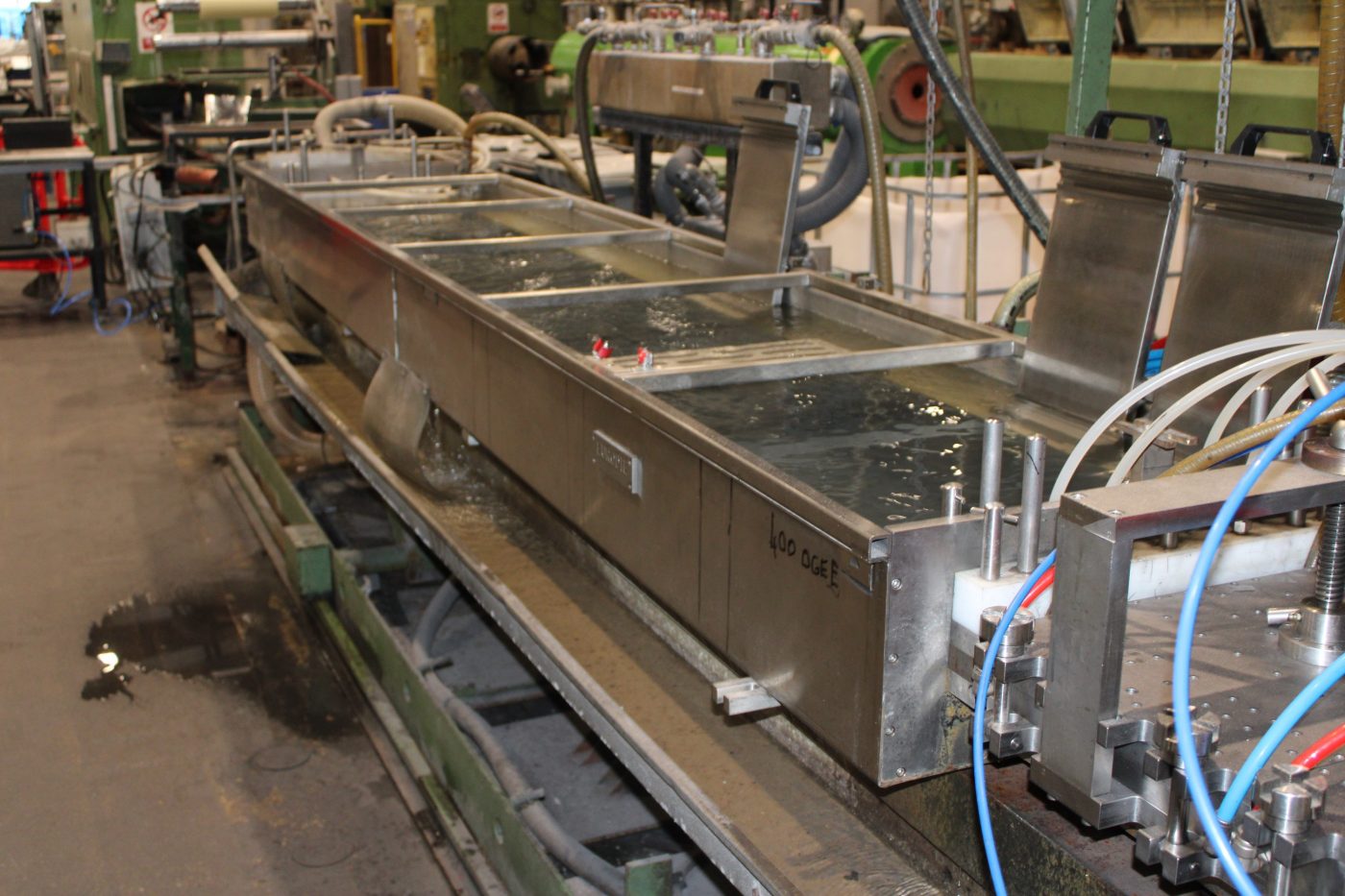 Plastic pipe being extruded in water bath