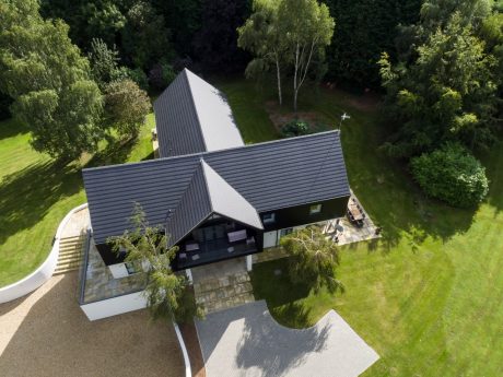 Areial shot of a large grey roof with surrounding greenery