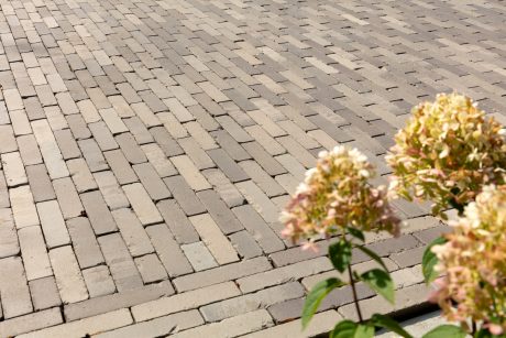 Multi tone grey paving with flowers in the corner