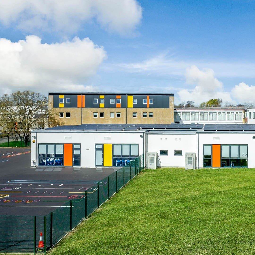 two story school with white facade and yellow and orange window details