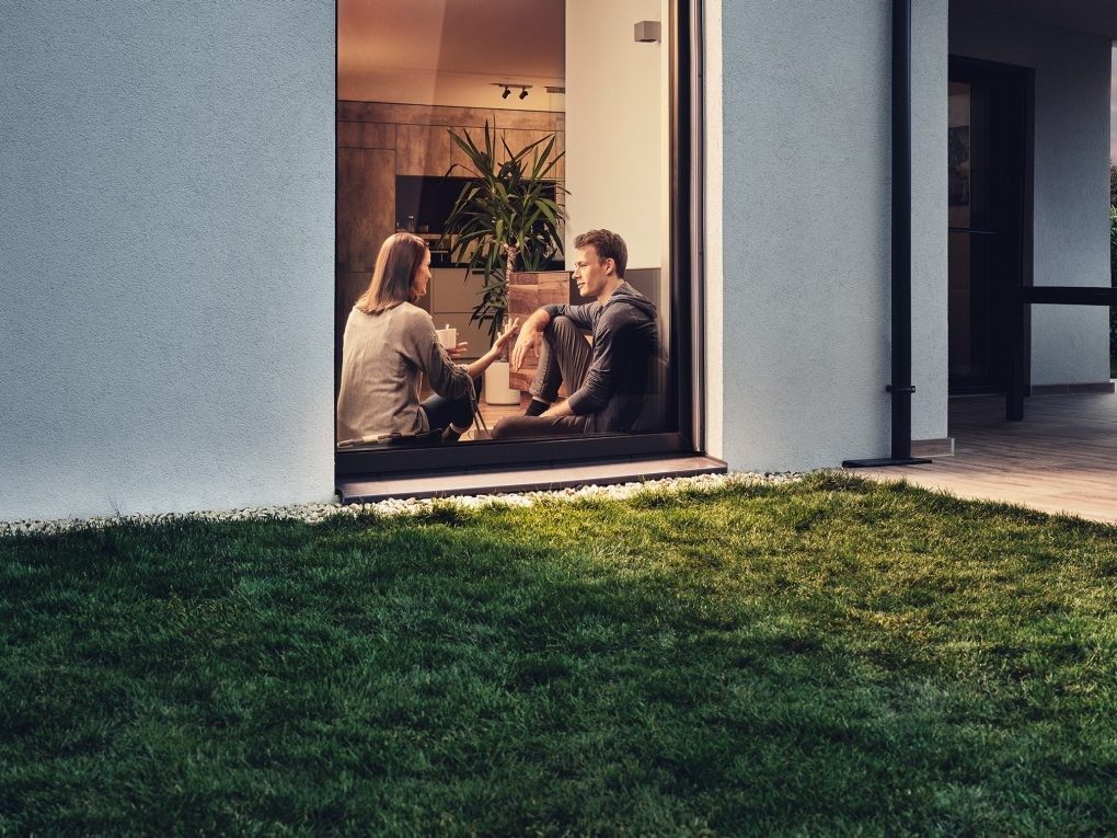 Couple sat in window of modern house talking