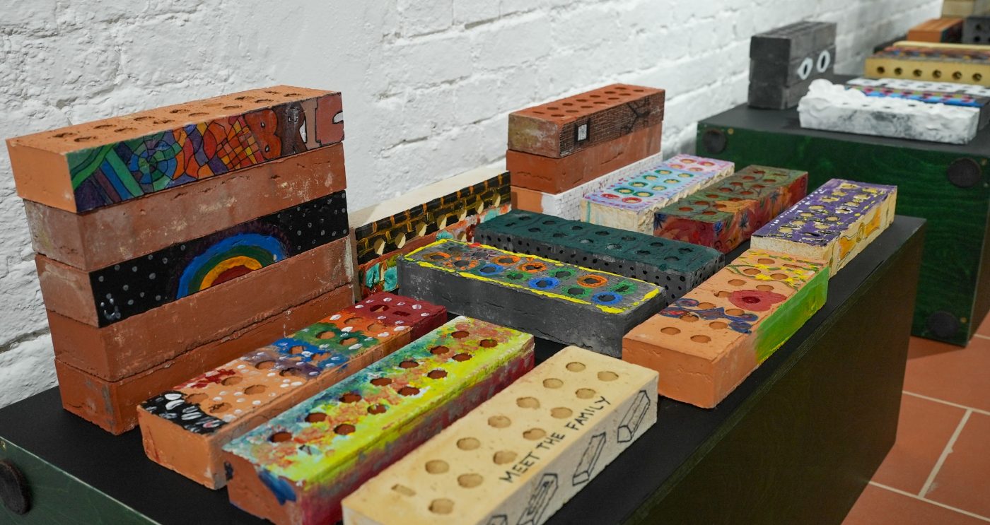 Row of colourful bricks lined up that have all been drawn on for the competition