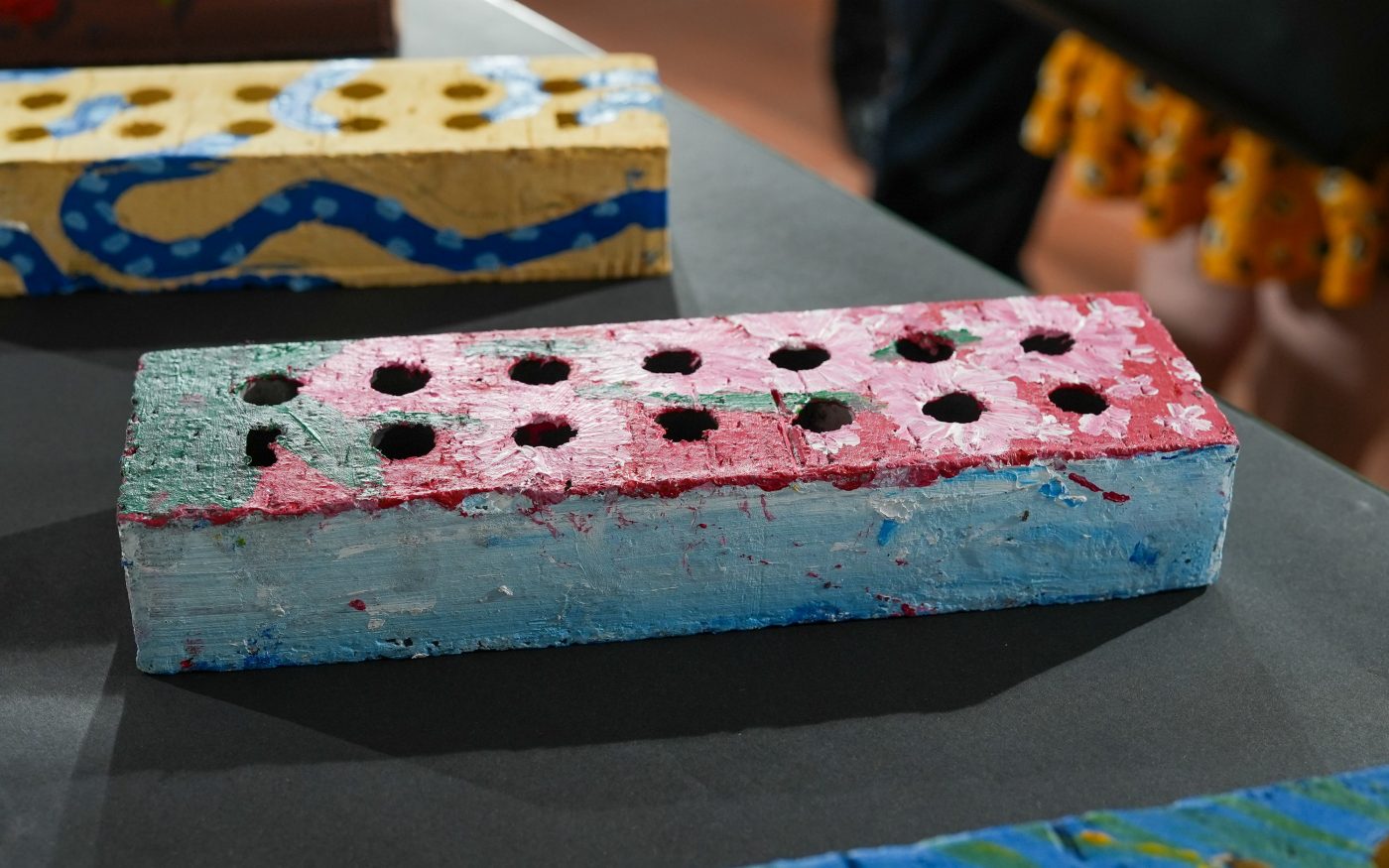 Brick that has been painted pink on the top and light blue round the sides