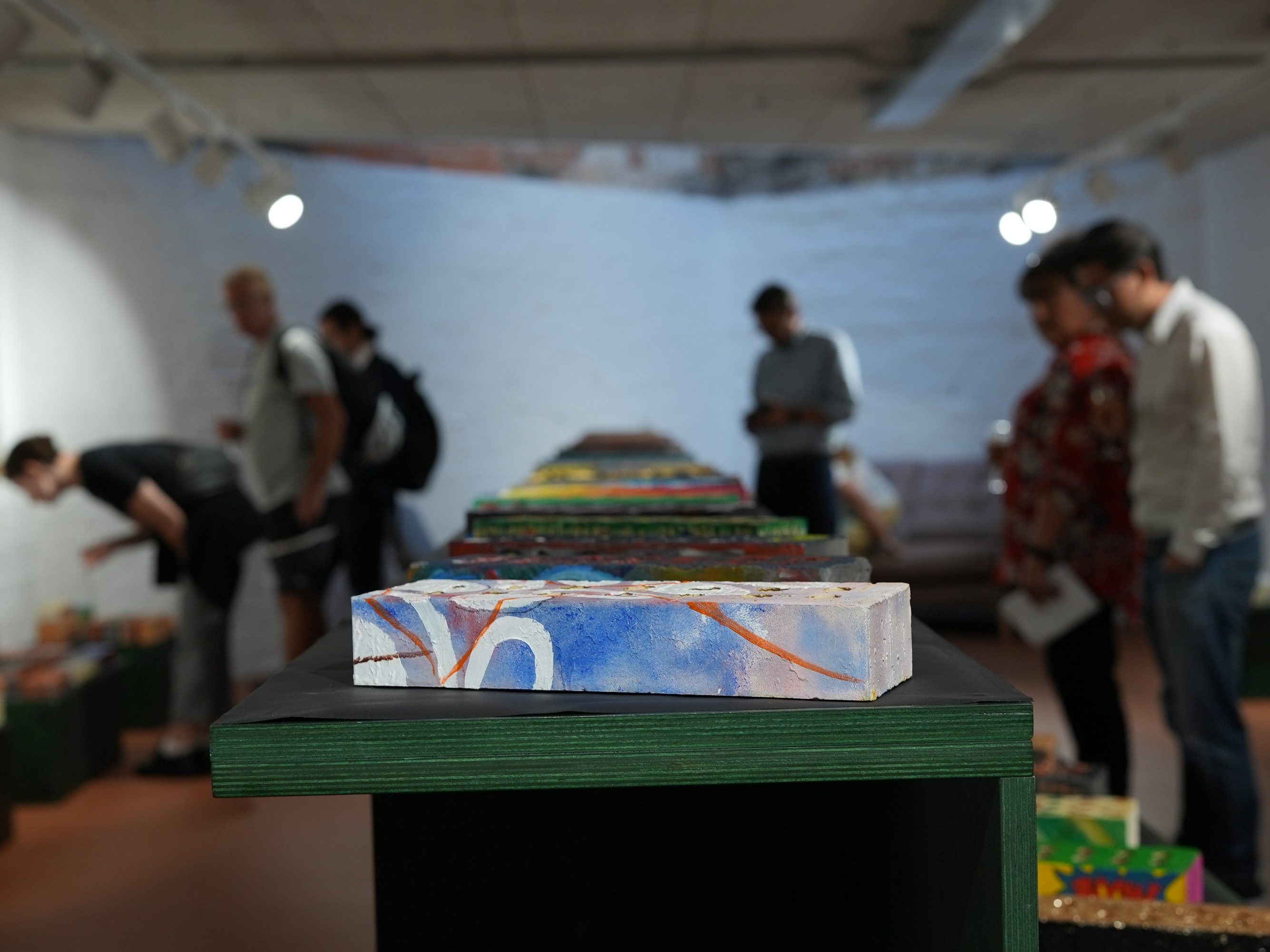 Bricks displayed on table that have been creatively decorative in different styles