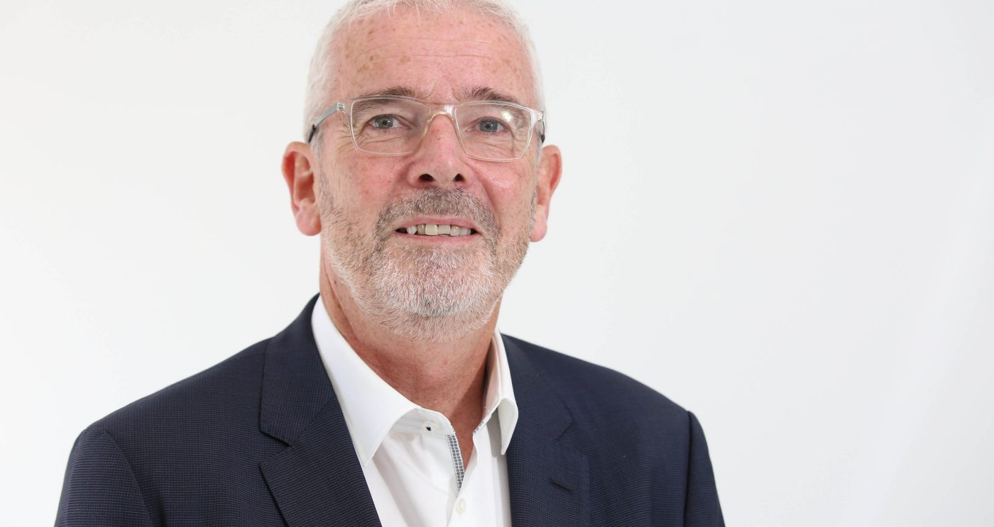 Headshot of Peter Minnis in suit with white background