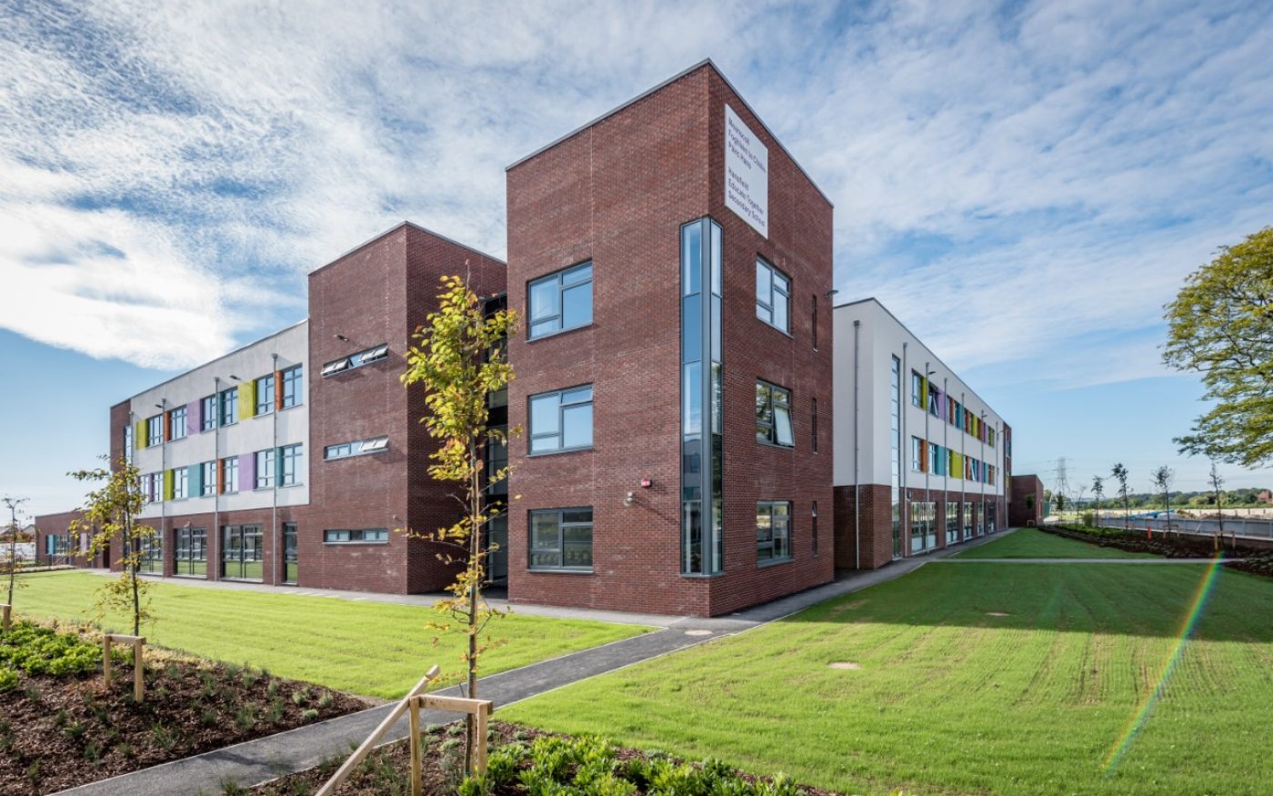 Hansfield Secondary School surrounded by green grass and blue sky