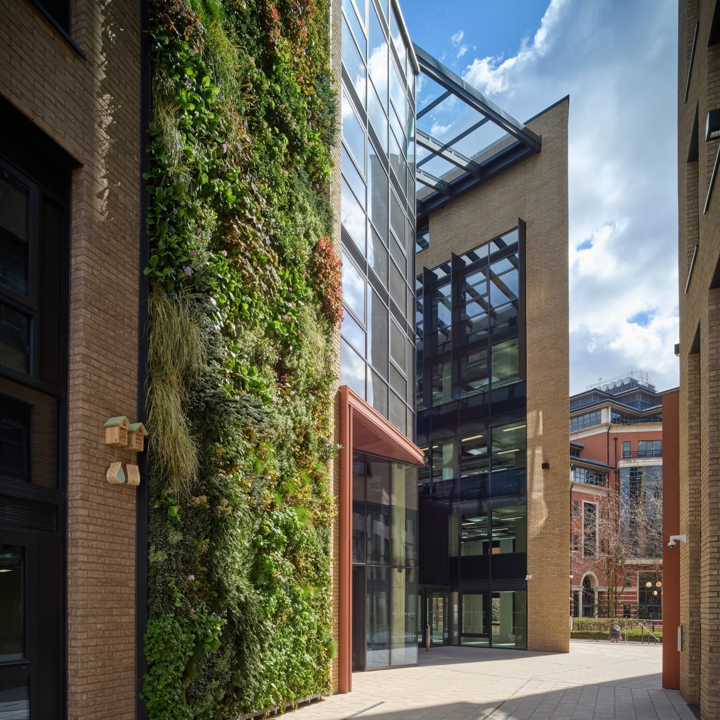 Exterior of modern office building with green wall and glass atrium