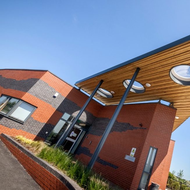 Modern school with wooden canopy and patterned brickwork