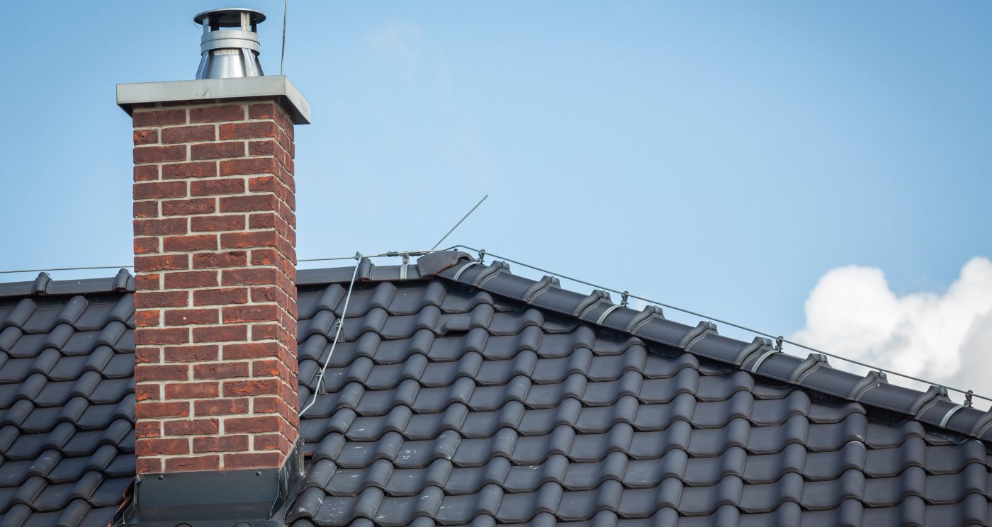Brick clad chimney on grey tiled roof