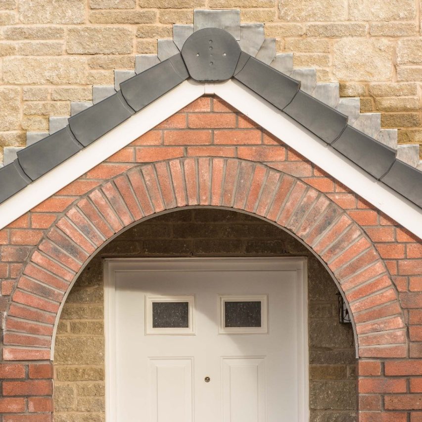 Brick archway above white door on brick house