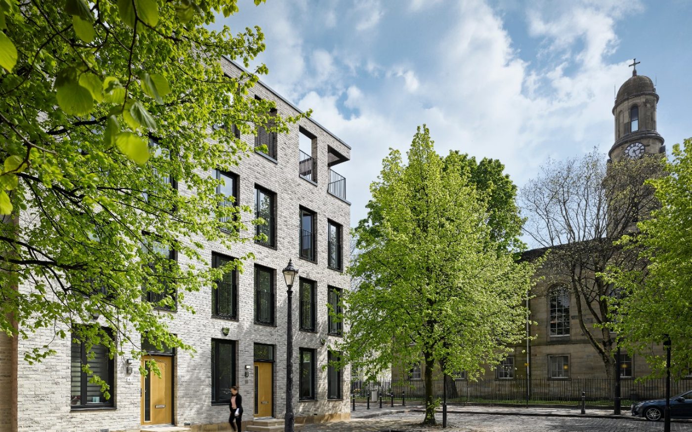 Grey brick terraced houses with trees