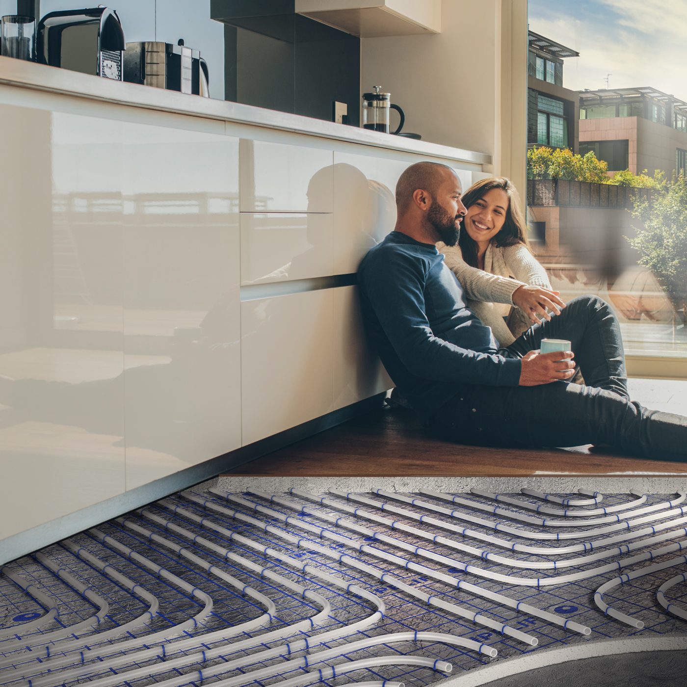 Man and woman sitting on kitchen floor with underfloor heating