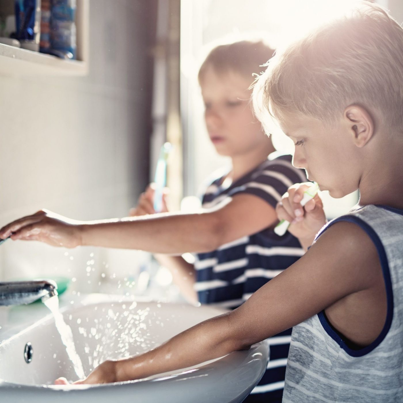 Two children brushing their teeth at bathroom sink
