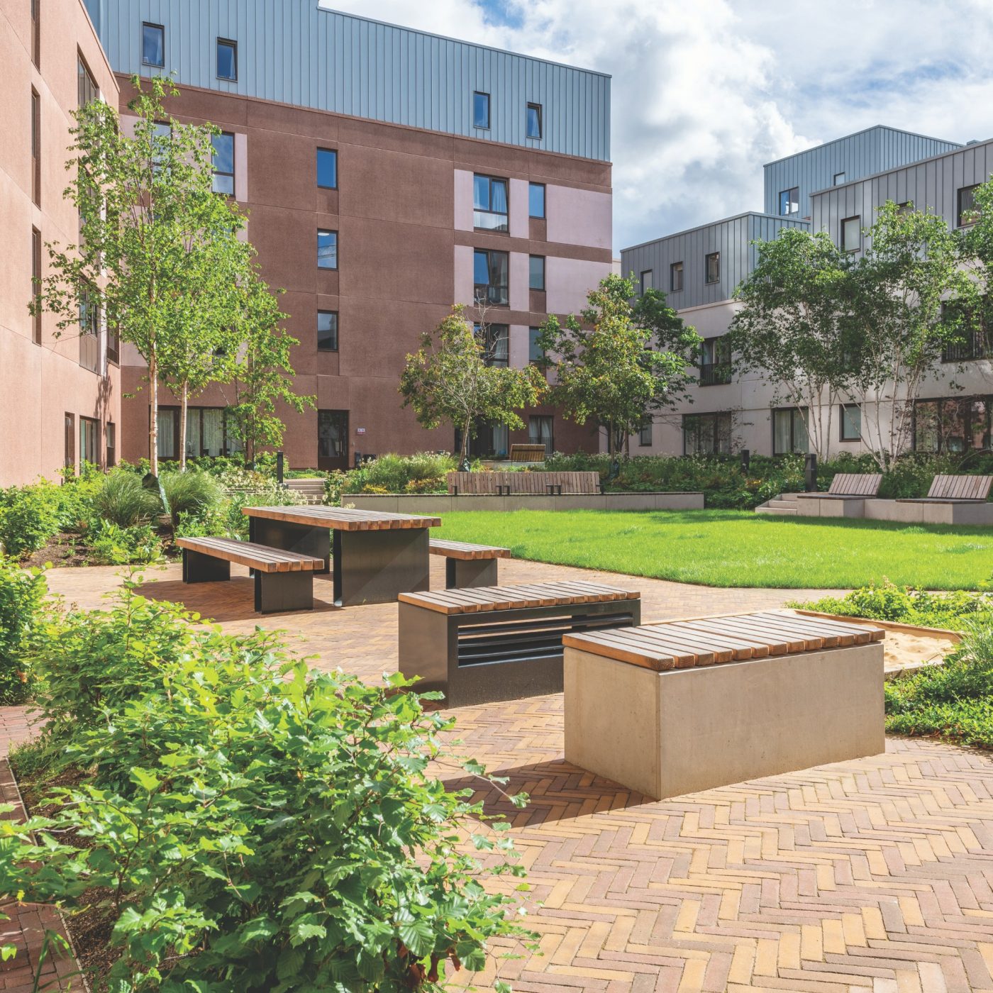 Students sitting in quad with modern paved landscape