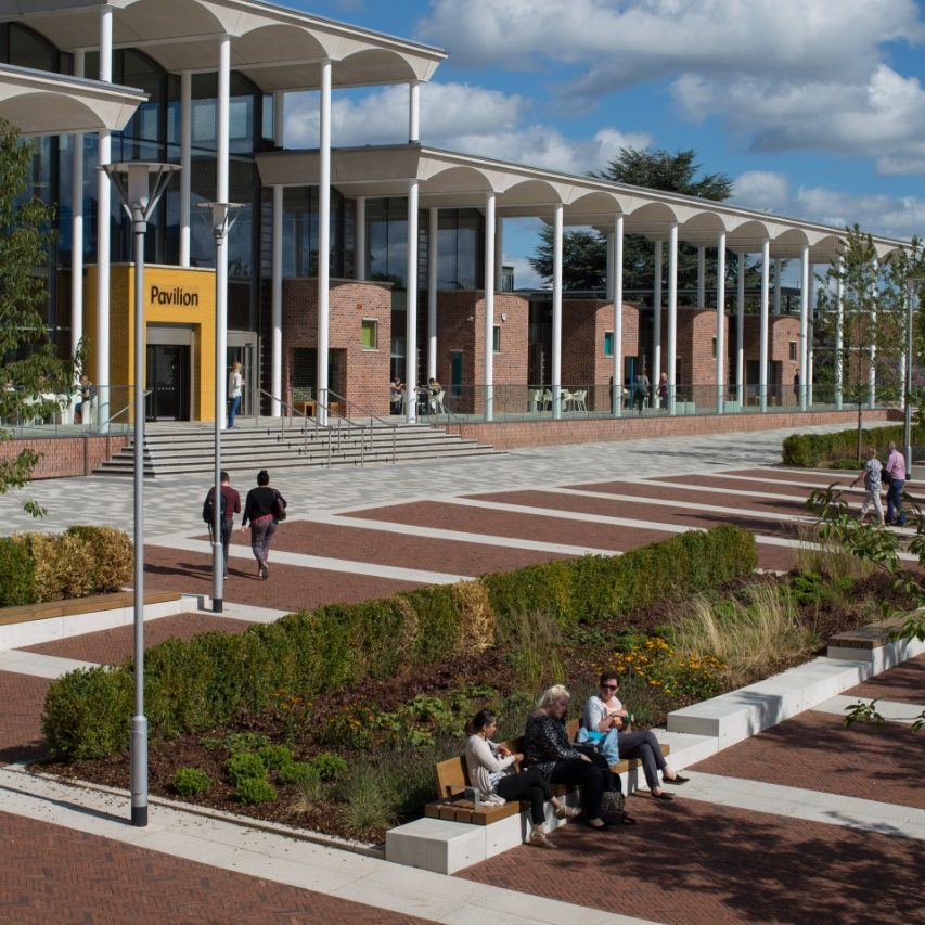 Students sitting in quad with modern paved landscape