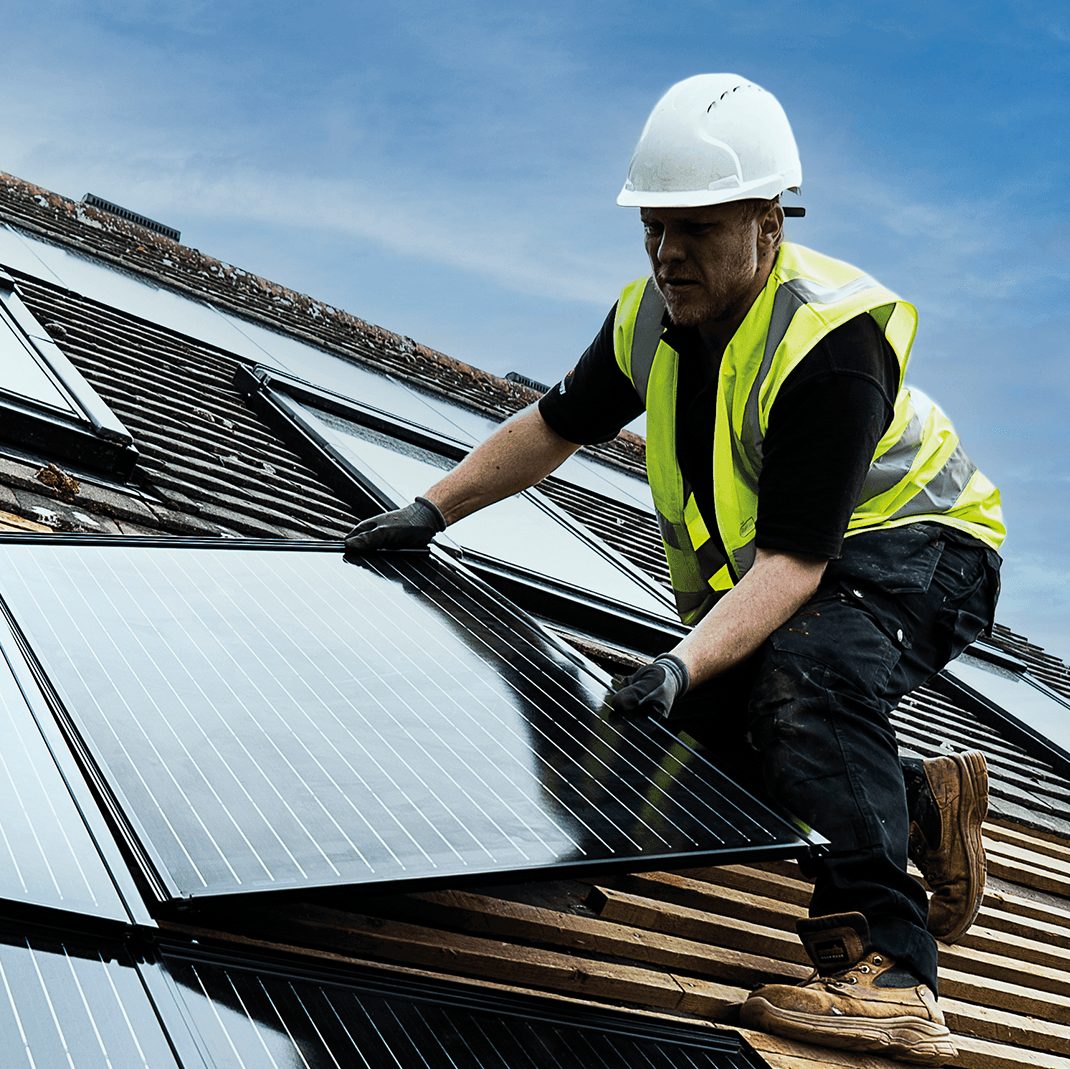 Man on roof installing in-roof solar panels