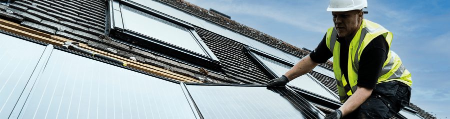 Accredited solar installer on roof installing panels